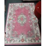 A pink ground Chinese washed wool floor rug.