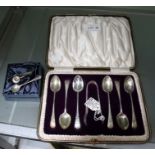 A cased set of silver coffee spoons with sugar nips. A silver condiment spoon and a silver napkin