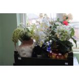 A box of assorted vases with artificial flower arrangements.