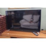 A Sharpe Aquos television with remote.