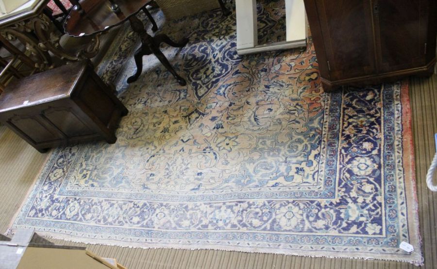 A large Persian design carpet (sun damaged)