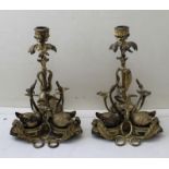 A pair of late 19th century gilded metal swan candlesticks