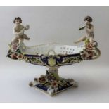 A Continental porcelain bowl, having musician putti at either end, 26cm high