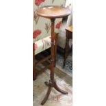 A reproduction mahogany finished saucer topped torchere stand on three downswept reeded legs, 99cm h