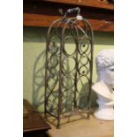 A free standing metal nine bottle wine rack.