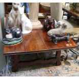 An imported hardwood low coffee table in a Spanish stylevwith cast iron stretcher, 50cm x 148cm x 97