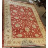 A red ground rug with floral central panel. 230 x 170 cm.