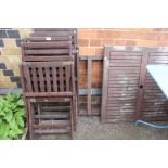 A folding teak patio suite, table and four chairs.