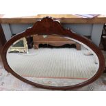 An oval mahogany framed wall mirror, marquetry decorated, plate size 57cm x 87cm