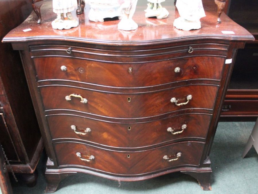 A reproduction mahogany serpentine fronted chest of four drawers, with brushing slide, on bracket fe