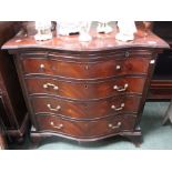 A reproduction mahogany serpentine fronted chest of four drawers, with brushing slide, on bracket fe