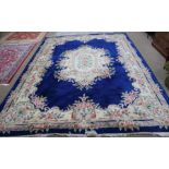 A large Chinese washed wool floor carpet, on dark blue ground with floral decoration, 374cm x 275cm