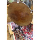 An early 19th century mahogany tilt top tripod table on cannon barrel column with bird cage action.