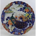 A large Japanese porcelain charger, painted in the Imari taste, all over design of Peacocks in a Peo