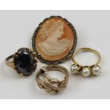 A cameo brooch in marcasite set frame, together with three costume rings