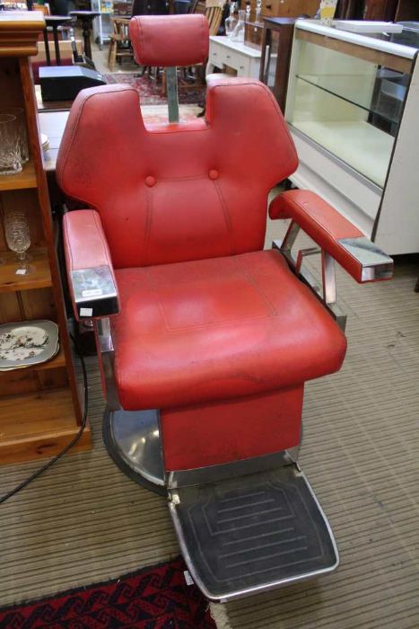 A pair of 1970's stainless steel framed adjustable barbers chairs with red vinyl pads