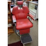 A pair of 1970's stainless steel framed adjustable barbers chairs with red vinyl pads