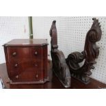 A pair of carved mahogany shelf brackets with a tabletop three drawer chest.