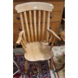 A late 19th century slat backed country kitchen armchair, with solid seat