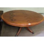 A reproduction Yew wood veneer oval coffee table, raised on central stem and four outswept supports