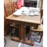 An oak rectangular topped dining table, having chip carved apron supported on twin plain columns, un