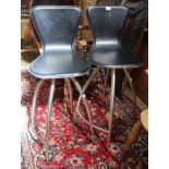 A pair of bar stools, black leather upholstered, swivelling on four leg metal bases