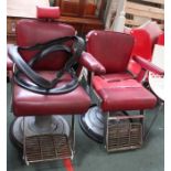 A matched pair of adjustable Barber's chairs with red vinyl upholstery