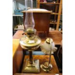 A brass oil lamp with chimney plus an electrified brass lamp with glazed shade.
