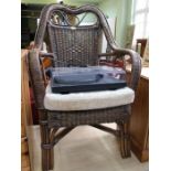 A wicker conservatory armchair with drop-in seat pad.