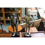 Two models of medieval knights on plinths.
