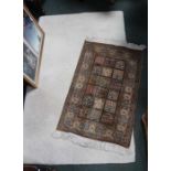 A small silk prayer rug and a modern textured hearth rug.