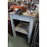 A small painted wooden two tier work table with bench vice attached