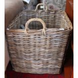 A large woven wicker square formed twin handled log basket