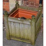 A square formed wooden planter with plastic liner
