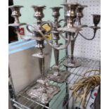 A pair of silver plated three light table candelabra with one other similar