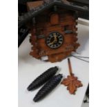 A traditional wooden Cuckoo clock, with pendulum and pine cone weights