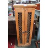 A rustic grille front two door cabinet