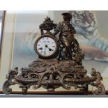 A 19th century patinated cast metal mantel clock, decorated with a gardener, having bell strike, wit