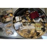 A tin containing vesta, yellow metal locket, medals, coins, pen knives, lighters, tokens etc