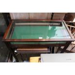 An Edwardian mahogany glazed jewellery display table with lockable fall down panel and velvet