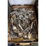 A box containing a large and varies selection of domestic cutlery