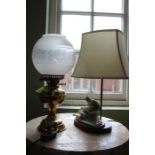 A brass oil lamp, electrified & a porcelain figural group lamp