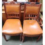 A pair of late 19th century carved walnut framed single chairs with studded leather back and seat