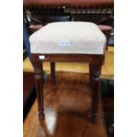 A late 19th century mahogany square pad top stool on four turned splayed legs
