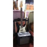 A Peavey Raptor black and white electric guitar with a Kustom 10 watt practise amp