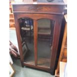 An oak glass front bookcase with box storage top