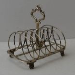 Robinson, Edkins and Aston, a Victorian silver toast rack, decorative central handle, raised on anth