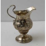 A George III silver cream jug, of baluster form, raised on three trefid feet, hallmarks to base