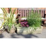 An ornate rectangular trough planter with contents, plus a round planter with contents
