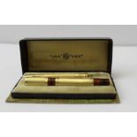 A French "Unic" 18ct gold plated pen and propelling pencil set, the pen with a partial marbled